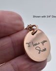Rose gold pendant with handwritten message 'I love you Shott' held in a hand