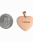 Rose gold heart-shaped pendant next to a quarter for size comparison on a white background