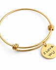 Gold bangle bracelet with a round engraved disc charm that reads 'I LOVE YOU', shown on a clean white background.