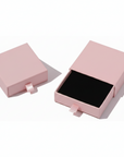 Pink jewelry box with a black interior on a white background
