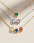 Three necklaces with colored gemstones on a beige background