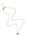 Gold necklace with a green gemstone pendant on a white background