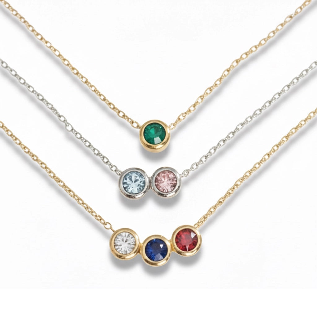 Three necklaces with colored gemstones on a white background