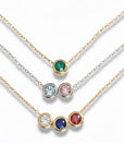 Three necklaces with colored gemstones on a white background