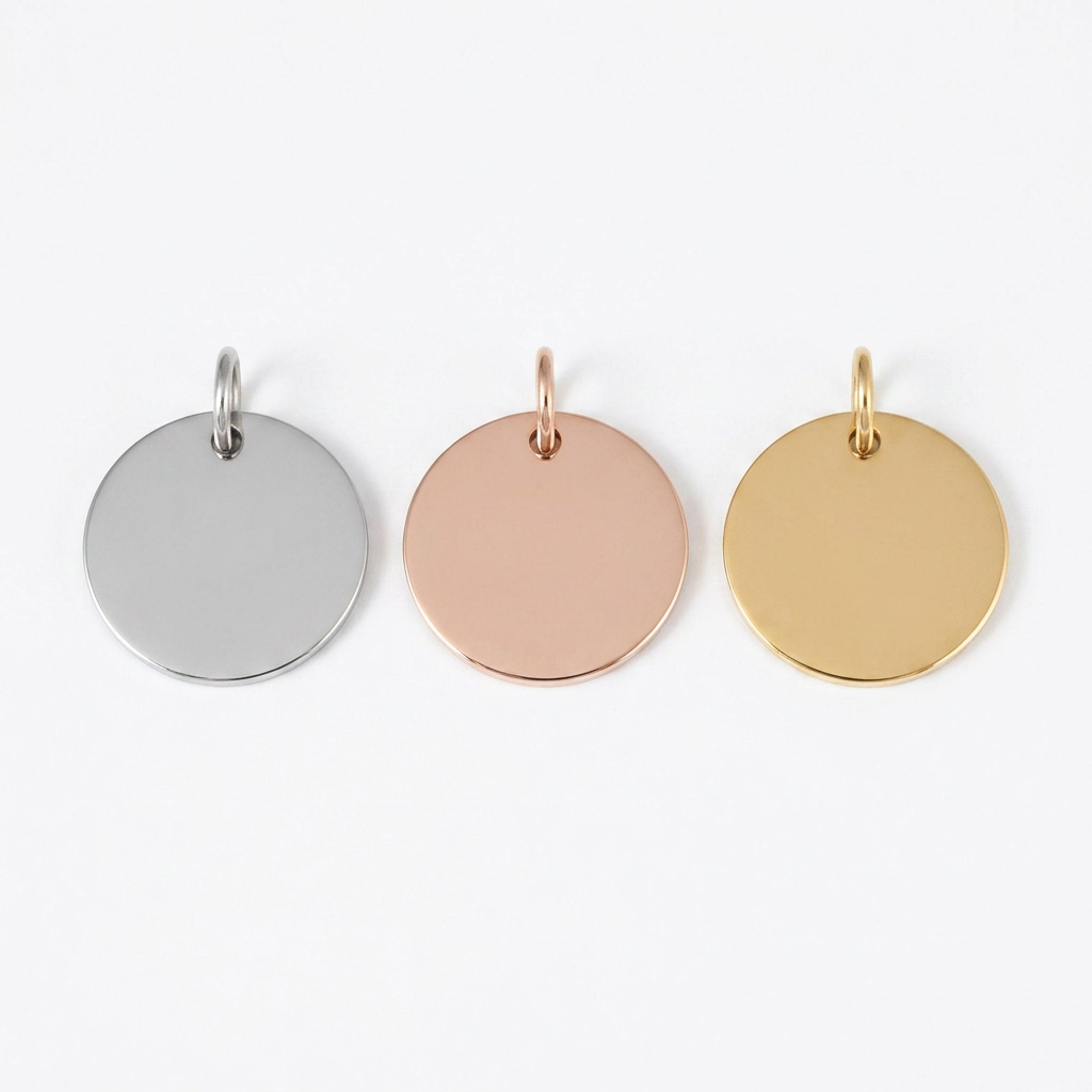 Three round steel pendants in silver, rose gold, and gold on a white background