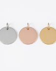 Three round steel pendants in silver, rose gold, and gold on a white background