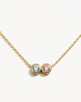 Gold necklace with two gemstones on a white background