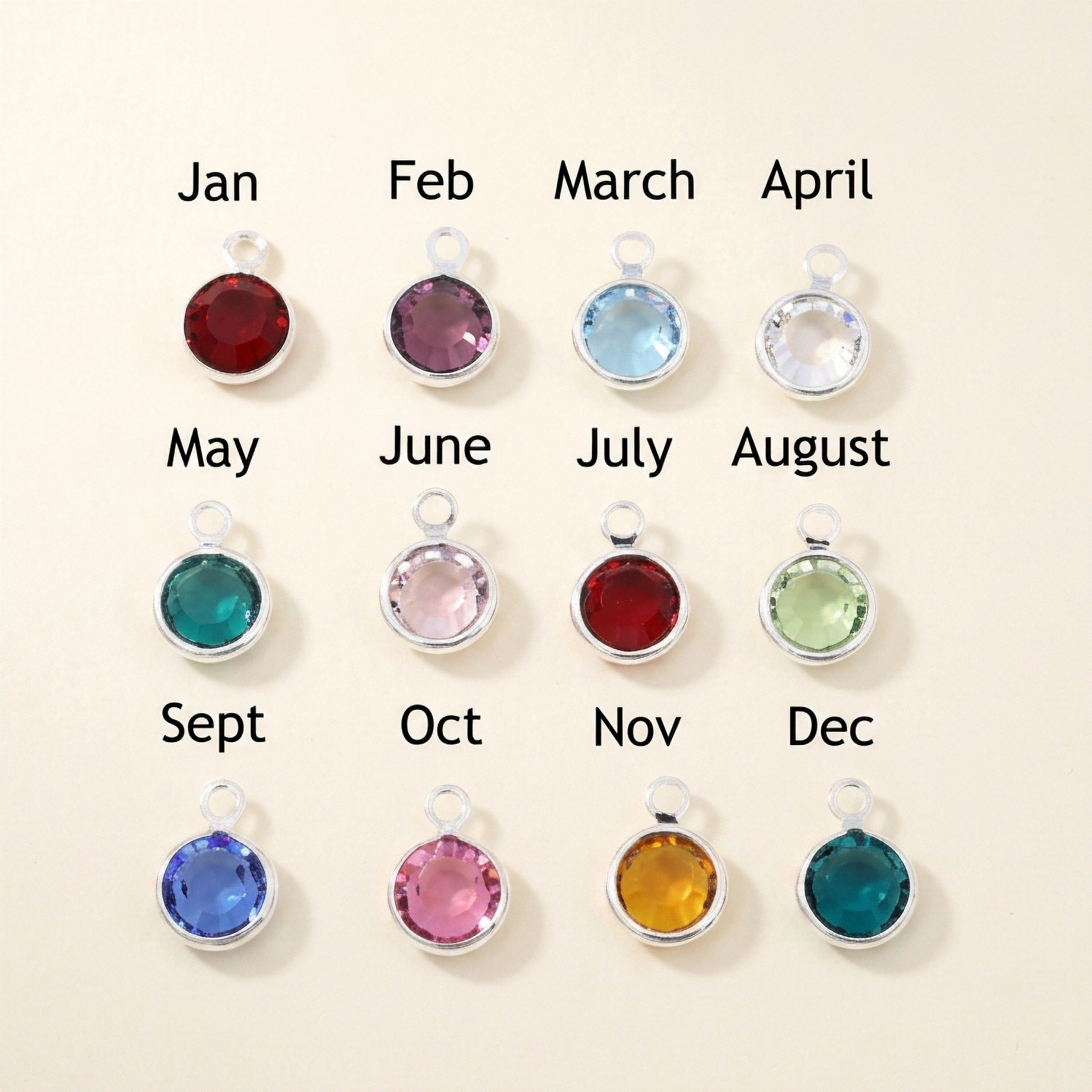  twelve birthstone charms with corresponding months on a beige background