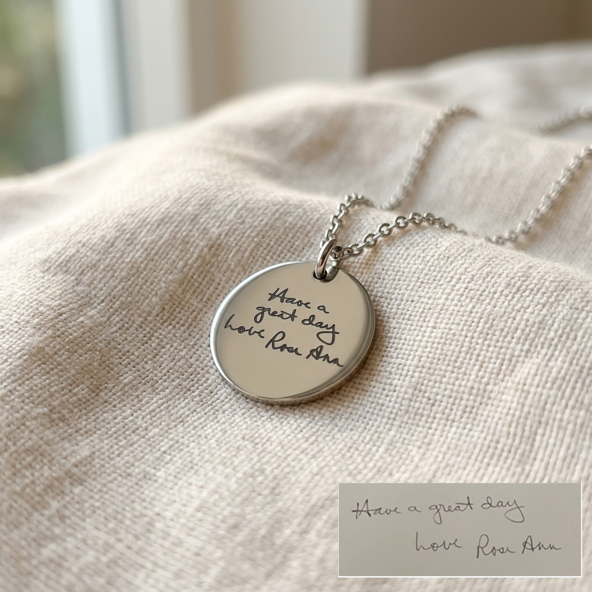 Silver necklace with engraved pendant on a textured surface