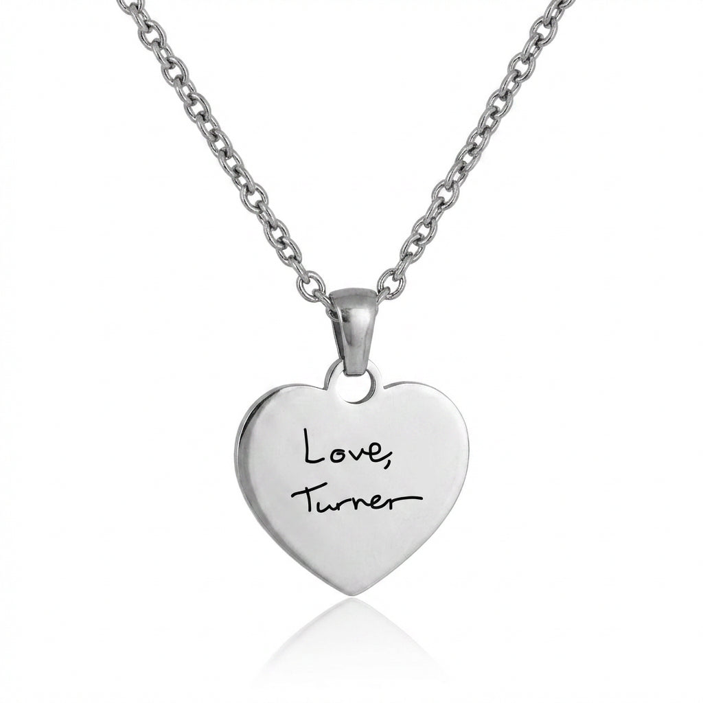 Silver heart-shaped pendant necklace with 'Love Turner' engraving on a white background